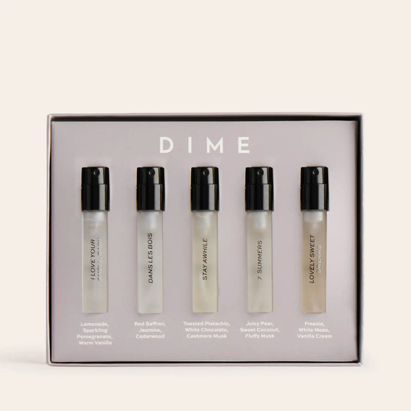 Five clear perfume sample vials with black spray caps in a branded box labeled "DIME."