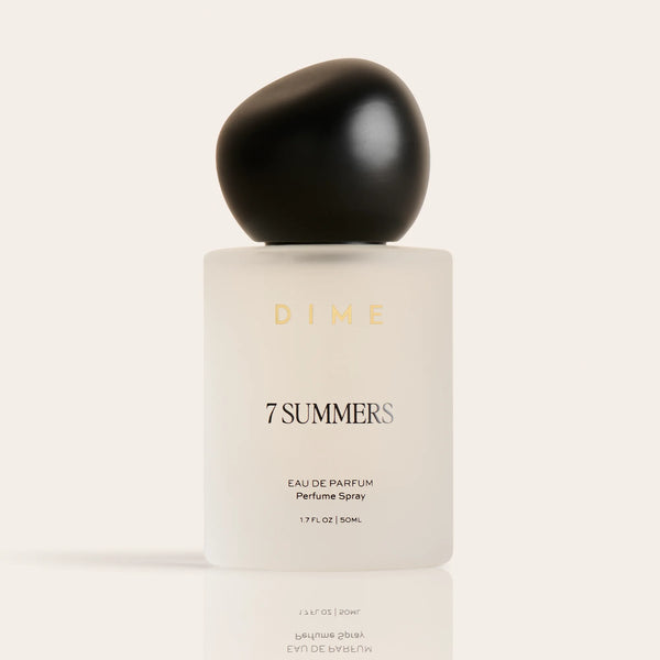 Round black cap atop cream-colored 7 Summers eau de parfum bottle labeled "DIME," 1.7 FL OZ size.