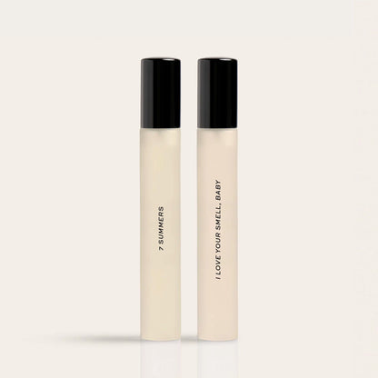 Two cream-colored fragrance rollballs with black caps labeled "7 Summers" and "I Love Your Smell Baby".