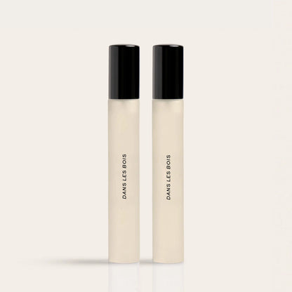 Two cream-colored fragrance rollerballs with black caps labeled "Dawns Les Bods" side by side.
