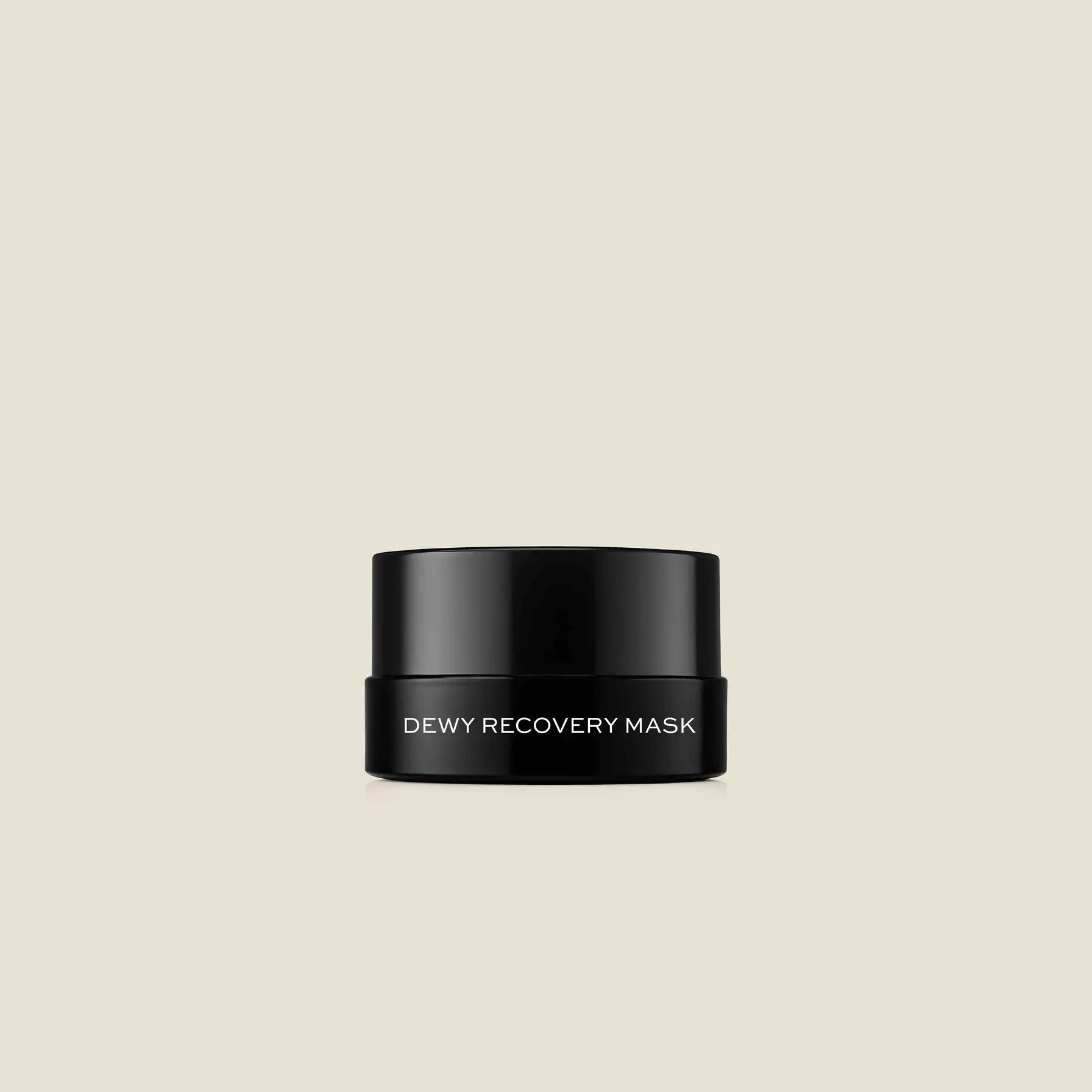 Black jar with white text reading "Dewy Recovery Mask" against a beige background.