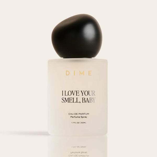 Cream-colored perfume bottle with black spherical cap labeled "I Love Your Smell, Baby" eau de parfum spray, 1.7 fl oz.