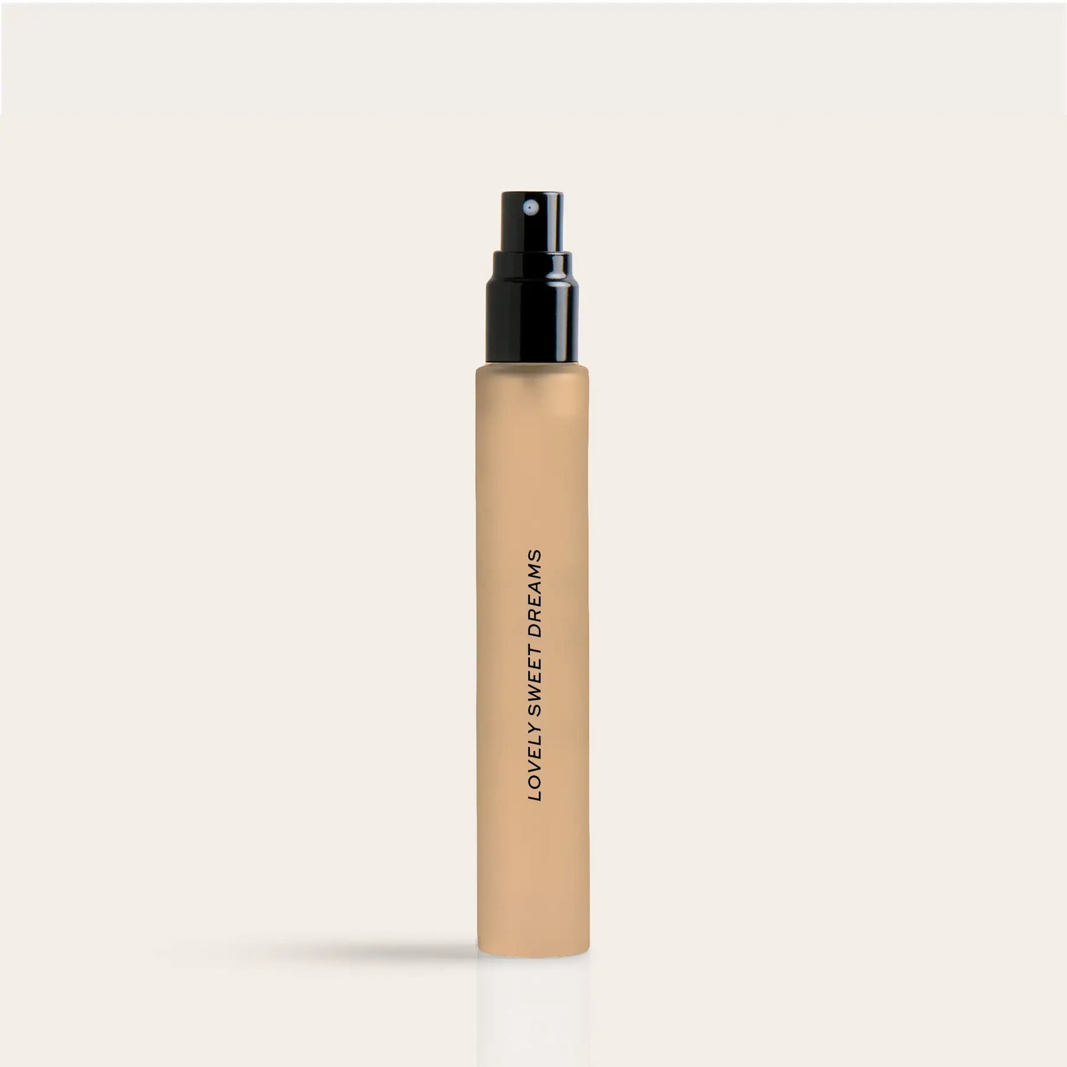 Beige cylindrical perfume travel spray bottle with black spray nozzle and "Lovely Sweet Dreams" text on label.