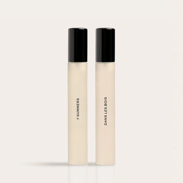 Two cream-colored fragrance rollerballs with black caps labeled "7 Summers" and "Damsel's Bows."