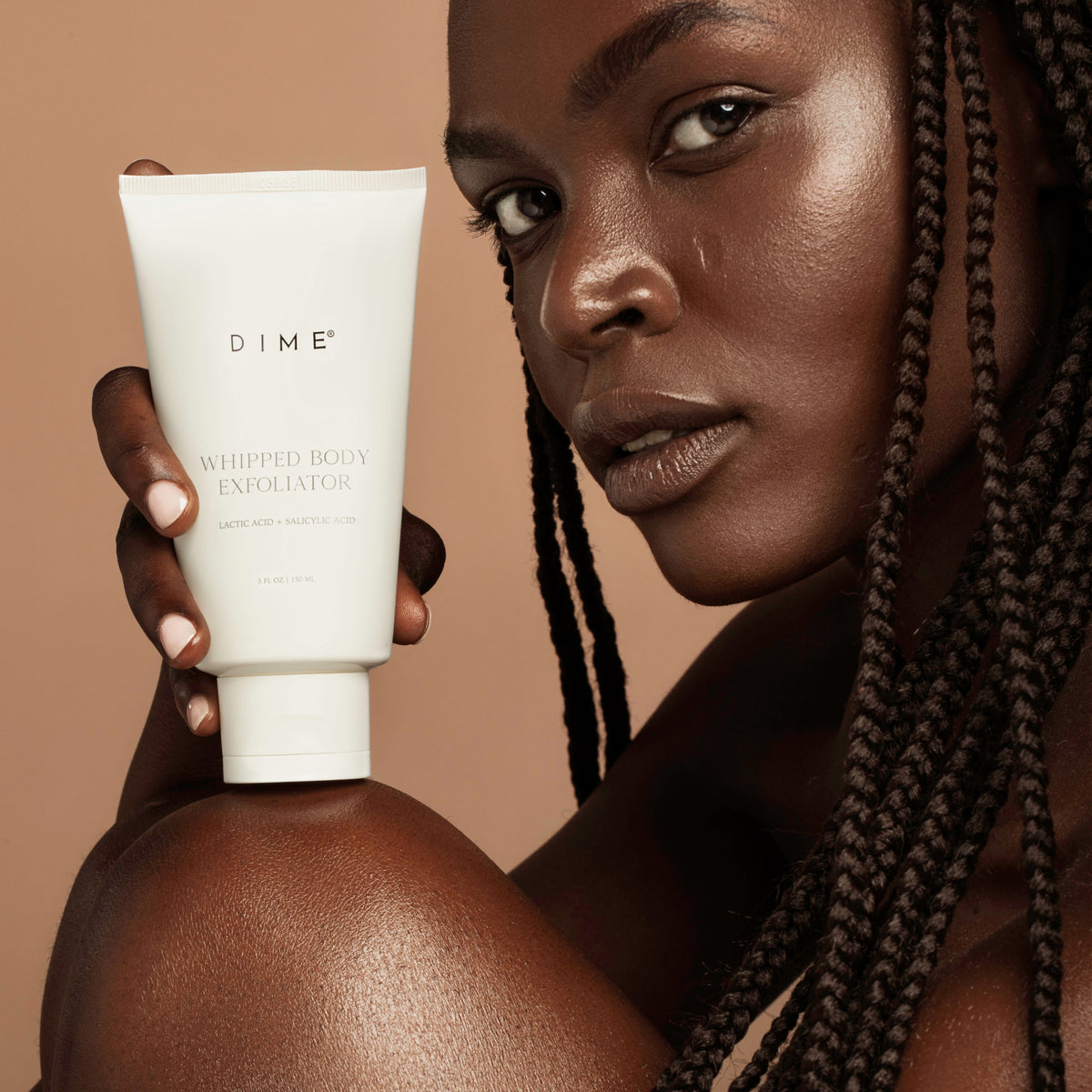 lifestyle of a girl holding the whipped body exfoliator product