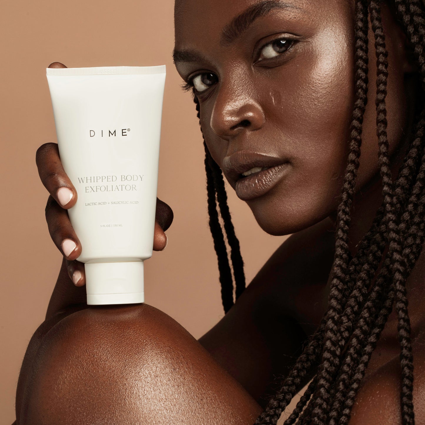 lifestyle of a girl holding the whipped body exfoliator product